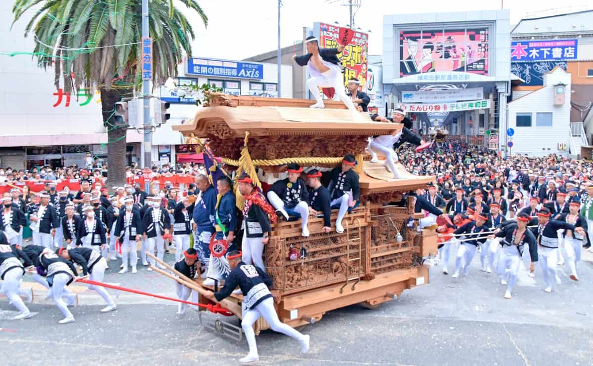 交差点を「やりまわし」で駆け抜けるだんじり〔写真提供：岸和田市〕。写真は大工町のだんじりで、お話を聞いた山本仲伸さんが彫り物を手掛けた。令和6年の岸和田だんじり祭の開催は、9月14日宵宮・15日本宮