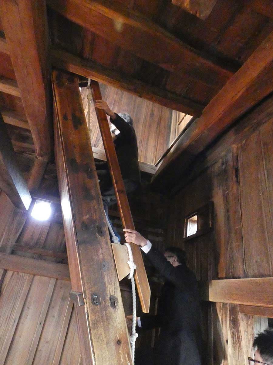 坂井市の池田禎孝（よしたか）市長と角明浩学芸員の案内で傾斜角約65度の丸岡城の階段を昇る山口さん