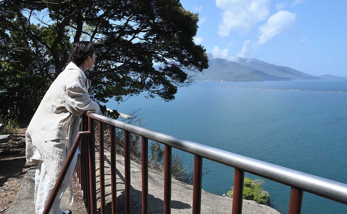 金崎宮を参拝する大東さん。海抜86メートルの月見御殿からは雄大な敦賀湾を見下ろせる