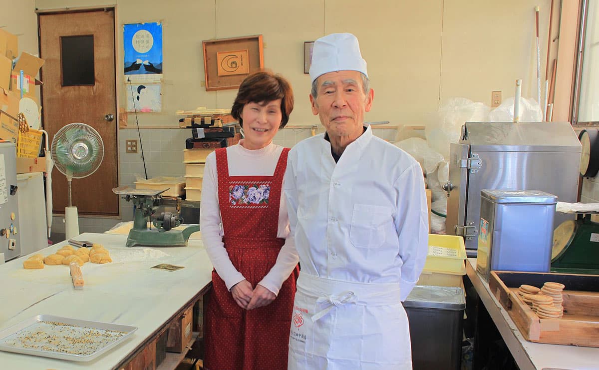 写真：大屋戸さんご夫婦。取材を受けながらでも二人で分担して、かたやきを返すタイミングを忘れない。その阿吽（あうん）の呼吸はさすが
